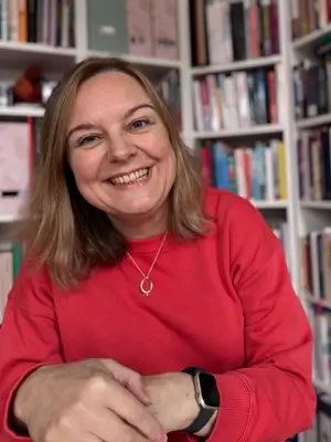 Natalie Cooper, smiling, hands held in front of her, looking into the camera.