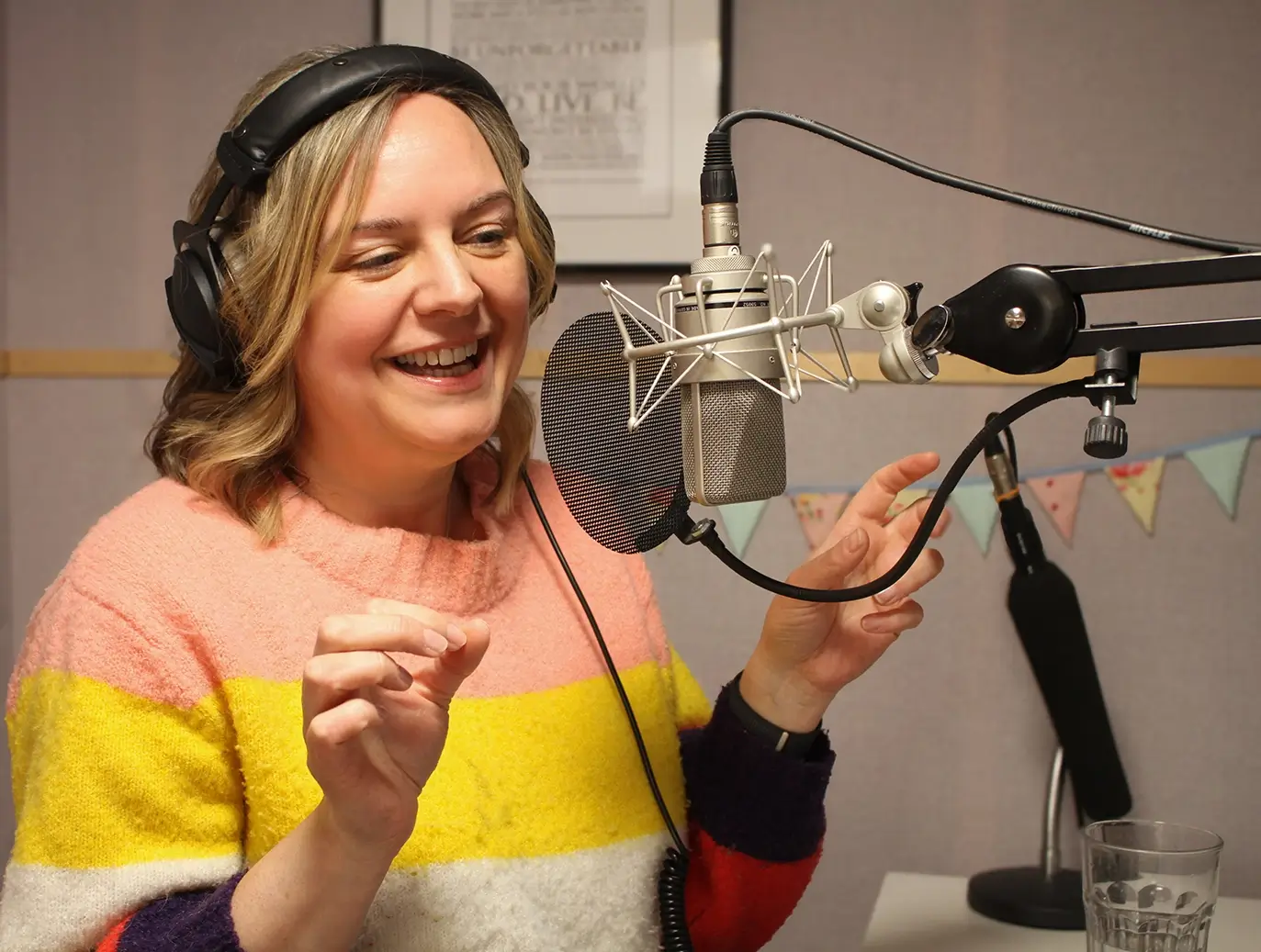 Natalie Cooper in voiceover session, talking into a microphone in a recording studio.