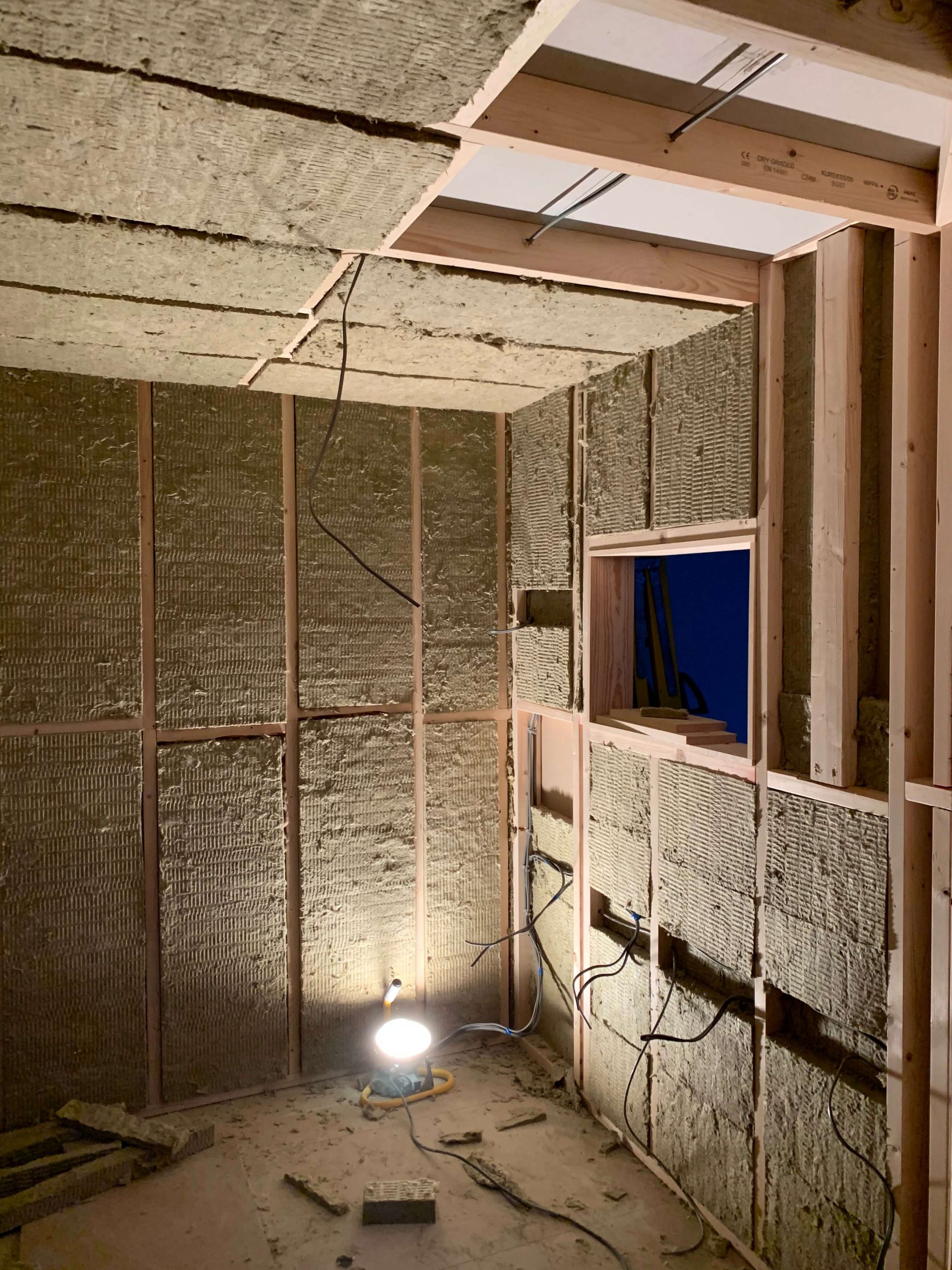 Rockwool slabs inserted between the internal framework of the booth with first fix electrics visible.
